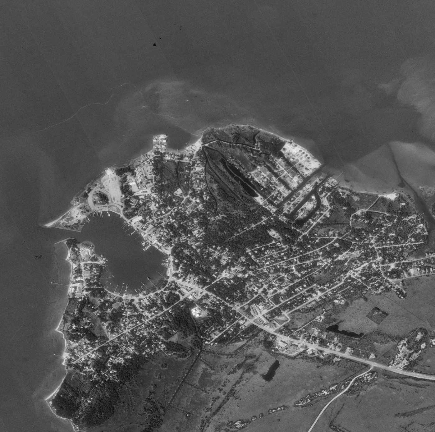 1993 black and white orthophoto of Ocracoke village showing Silver Lake harbor, the ferry terminal, NC 12 and the wooded point at Springer's Point